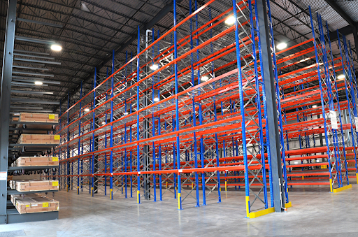 Palettier cantilever industriel installé en entrepôt, conçu pour le stockage de charges longues et volumineuses sur plusieurs niveaux.