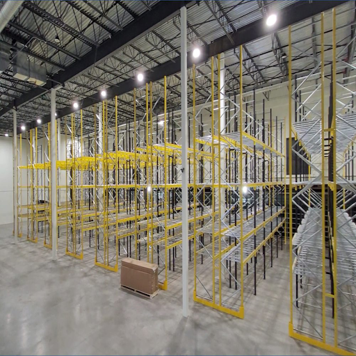 Industrial drive-in pallet racking system with safety guards and deep-lane storage structure for high-density warehouse applications.