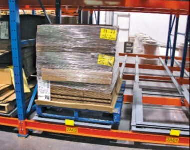 Pallet loaded on a push back racking system in a warehouse, illustrating a gravity-fed high-density storage solution.