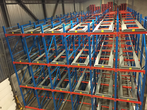 Push back racking system with gravity-fed carts for high-density pallet storage in a warehouse.